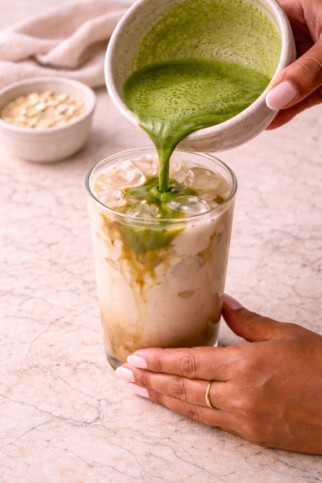 Step 4: Pouring whisked matcha into an iced oat milk latte