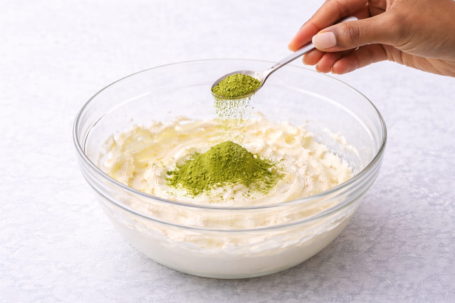Step 2: Adding sifted matcha powder to cream cheese frosting